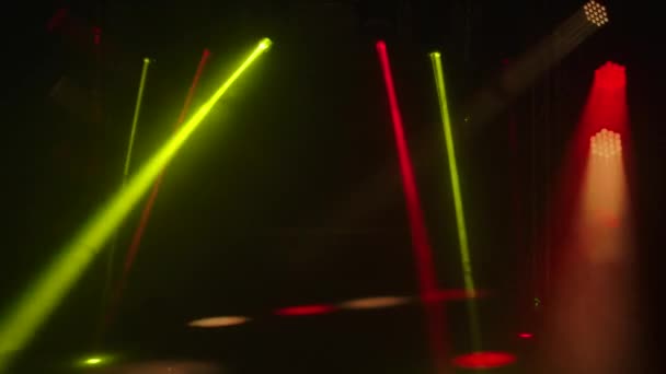 Красочные лазерные огни на сцене. Spotlights вращается, поворачивает и излучает красный и желтый свет в темной дымной студии. Показ голограмм. Осветительное оборудование и эффекты для праздников и вечеринок. — стоковое видео
