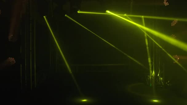 Barevná jevištní světla rozsvěcují tmavé studio. Bílé reflektory a žluté laserové hologramy vydávají jasné paprsky. Osvětlovací zařízení, světelné efekty pro představení, diskotéku nebo párty. Zavřít. — Stock video