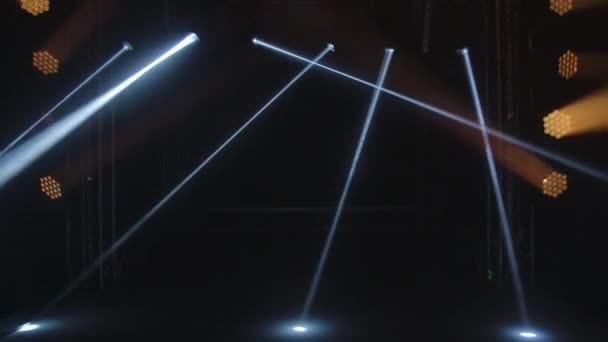 Färgglada scenljus. Guld spotlights och vit laser hologram snurrar, vänder och avger ljus ljusa strålar. Belysningsutrustning och ljuseffekter för design, konsertsal och scenbelysning under show — Stockvideo