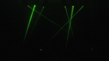 Şenlikli performans. Farklı renklerdeki lazer ışınları koyu arkaplana soyut ışık saçar. Partide renkli lazer ışıkları. Profesyonel renk aydınlatma ve ses gösterimi efektleri.