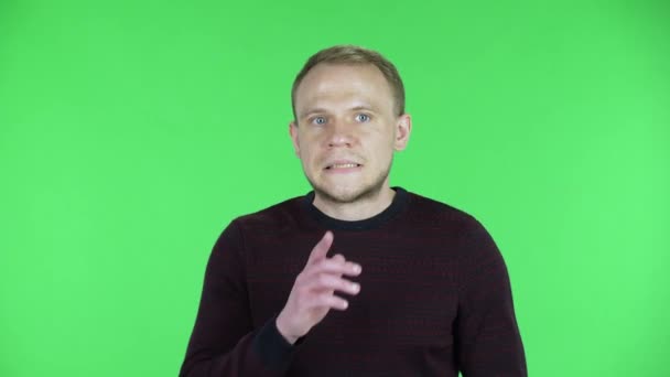 Portret van mannen van middelbare leeftijd die rondkeken, mond bedekten met zijn hand en geheim fluisterden en zwijgzaam gebaar maakten. Ongeschoren man in trui poserend op een groen scherm in de studio. Sluiten.. — Stockvideo