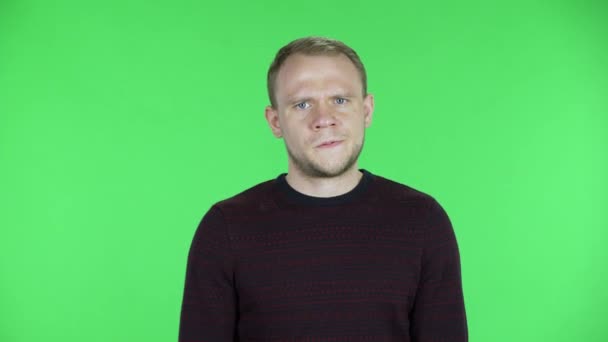 Retrato de un hombre de mediana edad ofendido y dio la espalda. Hombre sin afeitar en un suéter rojo negro posando en una pantalla verde en el estudio. De cerca.. — Vídeos de Stock