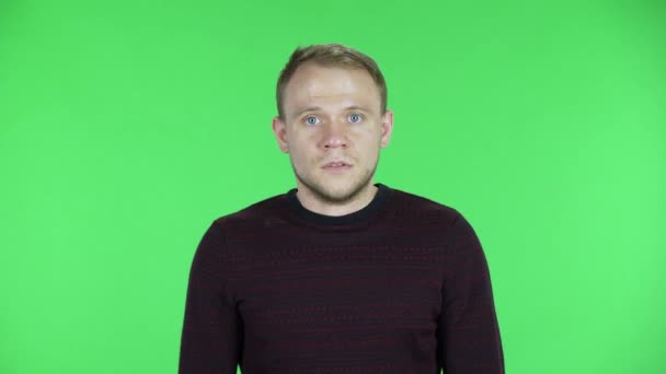 Портрет чоловіків середнього віку, що розмовляють з кимось із обуренням. Нездурілий чоловік у чорно-червоному светрі позує на зеленому екрані в студії. крупним планом . — стокове відео
