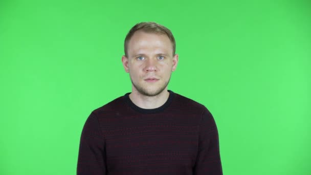 Portrait of a middle aged confused men saying oops and shrugging. Unshaven male in a black red sweater posing on a green screen in the studio. Close up. — Stock Video