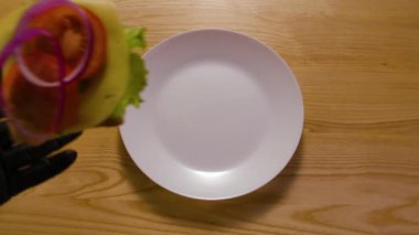 Taze ekmek, peynir ve sebzelerden yapılan lezzetli sandviç sabah kahvaltısı sırasında beyaz tabağa düşer. İş gününden önce doyurucu kahvaltı kavramı. Kapatın. Yavaş çekim.