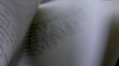 Kitap sayfalarında İngilizce metnin ayrıntılı görünümü. Anahtar mesajlar pembe ve mavi mermilerle vurgulanır. Siyah arka plan üzerine bir kitap. Öğrenme ve eğitim kavramı. Ağır çekim. Kapat..