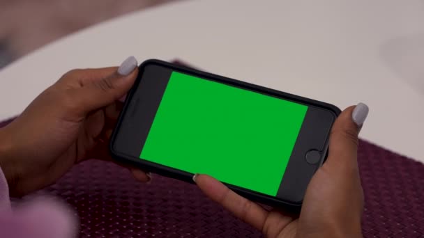 Mani nere femminili utilizza smartphone con chiave cromatica schermo verde. Pochi tipi di movimento scorrimento, toccando, zoom dentro e fuori. Perfetto per la composizione dello schermo. Colpo alla spalla. Chiudete. Rallentatore. — Video Stock