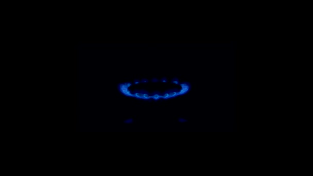 Het fornuis gaat aan en een blauwe vlam verschijnt in slow motion op een zwarte achtergrond. Aardgasontsteking van dichtbij. — Stockvideo