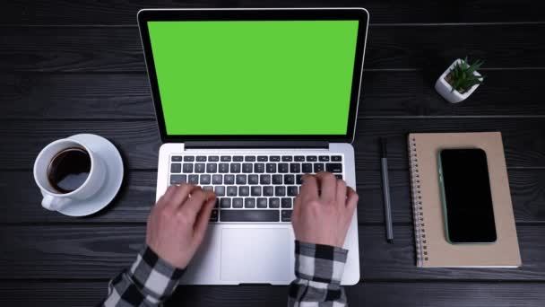 Girls hands are typing on a green laptop screen in slow motion. View from above. Work from home, telework and selfisolation. Place a template for your text or image, advertising content. Close up. — Stock Video