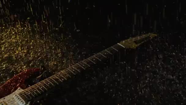電気ギターの上のカメラスライドは、暗いスタジオで黄色の光に照らされた水の表面にあります。光沢のある雨滴は、楽器や水に落ち、細かいスプレーを作成します。閉めろ。スローモーション. — ストック動画