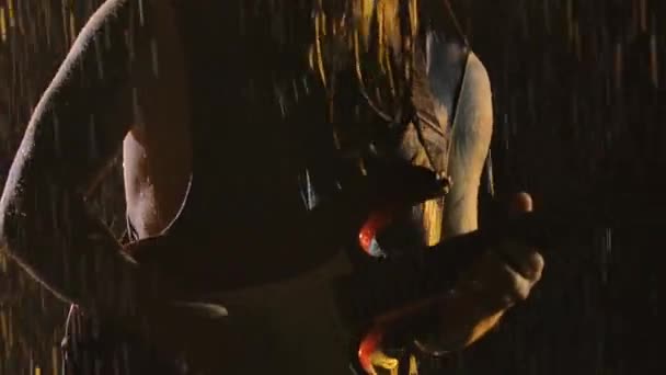 นักดนตรีร็อคเล่นกีตาร์ไฟฟ้าสีแดงสีขาวในสตูดิโอมืดกับพื้นหลังของหยดฝนตก ปิดขึ้นของมือผู้ชายเล่นบนสตริงกับเลือกกีตาร์ การเคลื่อนไหวช้า . — วีดีโอสต็อก