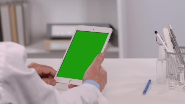 Male doctor consults patient using tablet with green screen chroma key. Online remote distance examination diagnosis by video call conference chat. Telemedicine, telehealth. Close up. Slow motion. — Stock Video