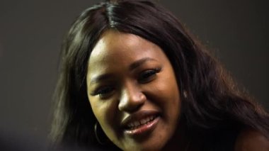 Gri arka planda müzikten hoşlanan sevimli, gülümseyen Afrikalı Amerikalı kadın. Siyah müzisyen sevgilisi için piyanoda ustaca bir melodi çalar. Romantik çift yakın çekim..