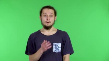 Talihsiz bir şekilde şok olan adam eliyle ağzını kapatır ve kafasını sallayarak tiksinti gösterir. Stüdyoda yeşil ekranda sakallı, siyah saçlı bir adamın portresi. Kapat..