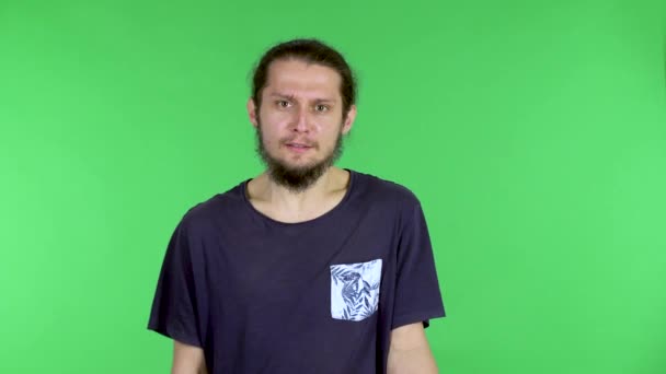 Retrato de un joven mirando a la cámara y diciendo que usted tiene la culpa, señala con el dedo al interlocutor y extiende sus manos. Hombre de pelo oscuro barbudo en el estudio en una pantalla verde. De cerca. — Vídeos de Stock