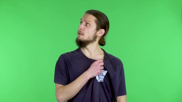 An exhausted young man suffering from heat waves his arms to create the wind. Man emaciated from heat, suffering from high air temperature. The guy in the studio on a green screen. Close up. — Stock Video