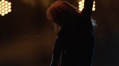 Çekici striptiz dansçıları direk üzerinde numaralar yapar. İç çamaşırlı ve yüksek topuklu seksi sarışın bir kadının silüeti. Karanlık bir stüdyoda dumanlı ve neon ışıklı egzotik bir dans. Kapatın. Yavaş çekim.