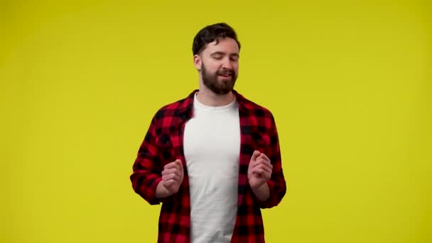 Positive man having fun, dancing, moving vigorously, pointing with index fingers directly at the camera. A man is isolated on a yellow background. Close up. Slow motion ready 59.97fps. — Stock Video