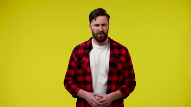 An unpleasantly surprised young man, says no, strongly disagrees, nods his head. A man in the studio on a yellow background. Close up. Slow motion ready 59.97fps. — Stock Video