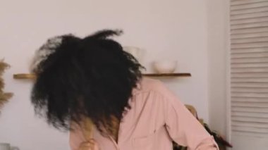 Afro-Amerikalı kadın ve kız neşeyle dans ediyor, şarkı söylüyor ve neşeyle sarılıyorlar. Anne ve kızı parlak bir mutfakta poz veriyorlar. Kapatın. Yavaş çekim hazır, 4K 59.97 fps 'de..