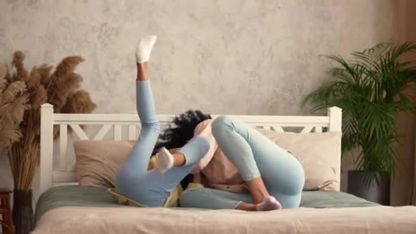 Femme et fille afro-américaine s'amusent à jouer et rire heureux. Mère et fille posant, couchées sur le lit dans une chambre à coucher avec un intérieur lumineux. Prêt au ralenti, 4K à 59,97 ips. — Video
