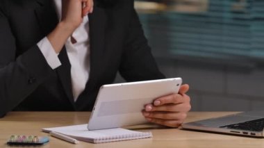 Afro-Amerikan kadın portresi dijital tablet ve dizüstü bilgisayardan bilgi alıyor. İş kadını iş yerinde poz veriyor, ofiste masada oturuyor. Kapatın. Yavaş çekim hazır 59.94fps.