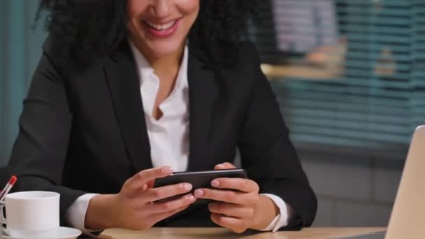 아프리카 계 미국인 여성 이 스마트폰으로 문자를 보내는 모습, 좋은 소식을 듣고 행복해 하는 모습, 승리를 축하하는 모습. 직장에서 일하는 사업가. 닫아. 느린 동작 준비 59.94fps. — 비디오
