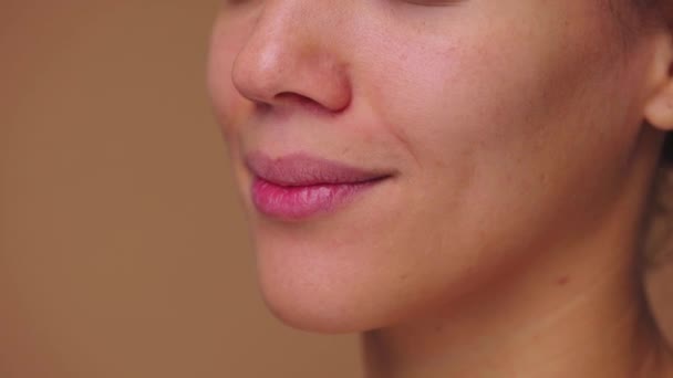 Hermosos labios femeninos sonriendo revelando dientes blancos. Rostro de una mujer afroamericana con belleza natural. Primer plano macro retrato. Vista lateral. Cámara lenta lista, 4K a 59.94fps. — Vídeos de Stock