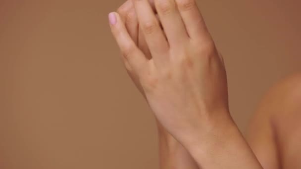 Afroamerykanka nakładająca krem na ręce. Zamknij makro portret dłoni mieszanej rasy żeńskiej, krem pocierający palcami. Zwolnij, 4K przy 59,94fps.. — Wideo stockowe