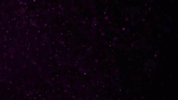Prachtig glinsterend stof op een zwarte achtergrond in roze licht. Langzame beweging. — Stockvideo