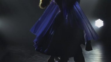 Zarif bir erkek dansçı ortağının etrafında vals yapıyor. Genç bir çift balo dansçısı karanlık bir stüdyoda sahne ışıklarıyla gösteri yapıyor. Siluetler. Kapatın. Yavaş çekim.