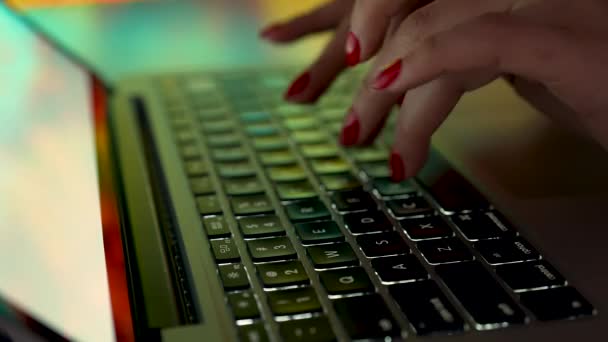 女性の手はコンピュータで働いている。学生の女の子は、ラップトップコンピュータのキーボード上のフリーランサータイプのテキスト。ぼやけた背景のテーブルに腰を下ろしていた女性。スローモーション。閉じろ!. — ストック動画