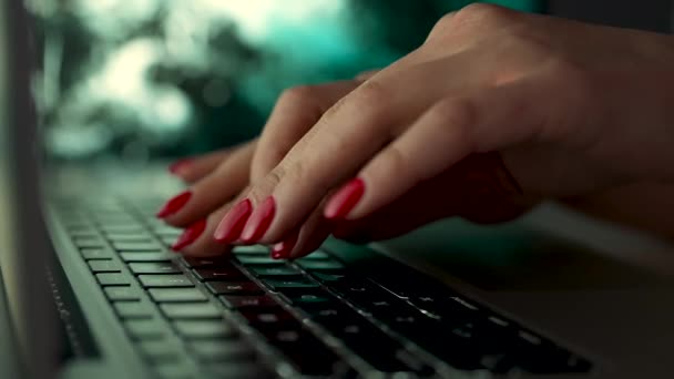 Szabadúszó nő piros manikűrrel dolgozik egy laptopon ül egy asztalnál homályos háttérrel. Közelkép egy nő kezéről és ujjairól, amint gépelnek egy laptopon. Lassú mozgás.. — Stock videók