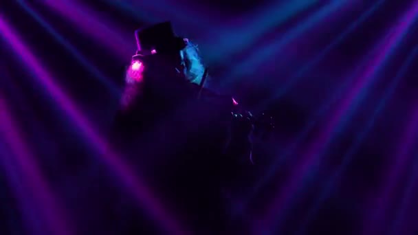 小提琴手在昏暗的演播室里表演的小提琴手，闪烁着蓝紫色的光芒。小提琴演奏，独奏会，现场表演，摇滚和古典音乐。靠近点. — 图库视频影像