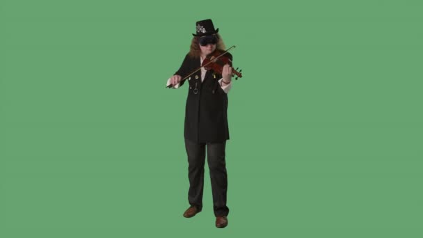 黒のスーツを着たヴァイオリニスト、帽子とオリジナルグラスが見事にバイオリンを演奏します。男は弓で弦に触れメロディーを作る。緑の画面のクロマキー。スローモーション. — ストック動画