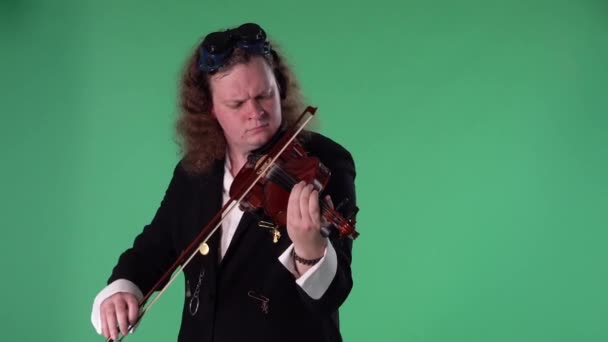 Un violoniste en costume noir et des lunettes originales sur sa tête joue magistralement du violon. L'homme touche les cordes avec un arc pour créer une mélodie. Clé chromatique à écran vert. Au ralenti. Gros plan. — Video