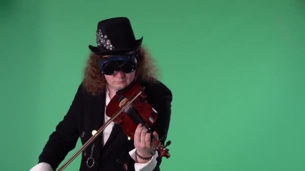 Ein Geiger in schwarzem Anzug, Hut und origineller Brille spielt die Geige meisterhaft. Der Mann berührt die Saiten mit einer Verbeugung, um eine Melodie zu erzeugen. Green Screen Chroma-Taste. Zeitlupe. Nahaufnahme. — Stockvideo