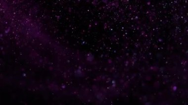 Pembe ışıkta siyah bir arkaplanda güzel bir ışıltı. Yavaş çekim.