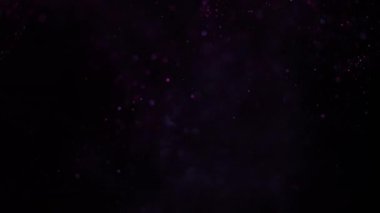 Pembe ışıkta siyah bir arkaplanda güzel bir ışıltı. Yavaş çekim.