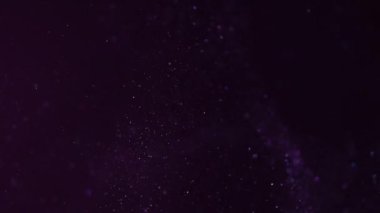 Pembe ışıkta siyah bir arkaplanda güzel bir ışıltı. Yavaş çekim.