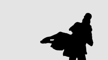 Siluet profesyonel bale çifti karanlık sahnede dans ediyor. Her harekette zarafet ve şefkat..