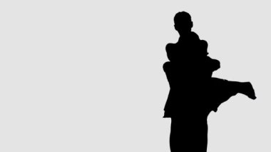 Siluet profesyonel bale çifti karanlık sahnede dans ediyor. Her harekette zarafet ve şefkat..