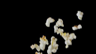 Popping Popcorn Flying and Falling Isolated on Black Background