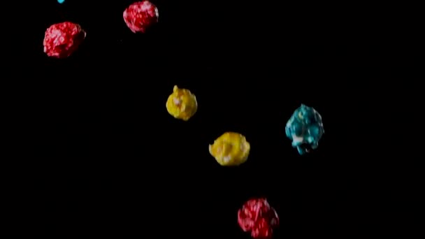 Разноцветный попкорн полет изолирован на черном фоне — стоковое видео