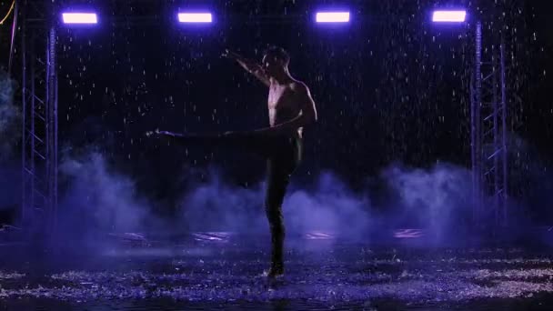 Zeitgenössisches Ballett, der Mensch führt Elemente moderner Choreographie auf und steht im Regen auf Oberflächenwasser. Sinnliche Bewegungen eines männlichen Tänzers mit nacktem Oberkörper. Silhouette. Zeitlupe. — Stockvideo