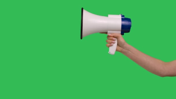 Megaphone gros plan rised dans la main féminine sur fond chroma écran vert clé. Haut-parleur blanc pour la performance sociale dans la main levée. Annonce spéciale, publicité ou diffusion. Mouvement lent. — Video