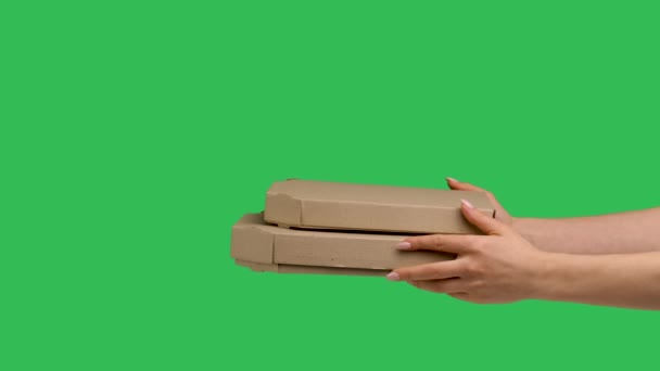 Female hands giving two cardboard box with pizza on background of green screen chroma key. Close up of box with snack for dinner. Fast courier delivery of food. Advertising of pizzeria. Slow motion. — Stockvideo