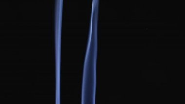 İki beyaz duman bulutlara karışıyor. Beyaz duman ve toz parçacıkları uzayda ağır çekimde siyah bir zemin üzerinde yüzerler. Kapat..