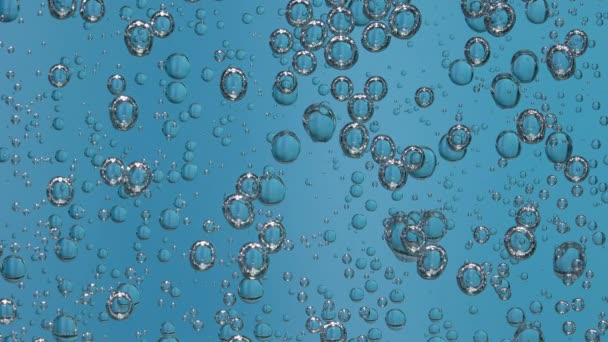 Beautiful bubbles in a glass of sparkling water on a blue background. Fascinating movement under the glass. Slow motion. Close up. — Stock Video