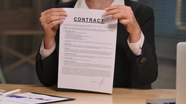 A mulher de negócios tem um contrato nas mãos e rasga-o. Mulher de fato de negócios preto senta-se à mesa no escritório. A rescindir contrato ou negócio rasgado. Fecha. Movimento lento pronto, 4K a 59.94fps. — Vídeo de Stock